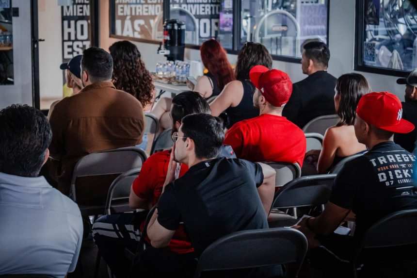 Público diverso acompanha atentamente um seminário em ambiente interno.