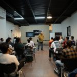 Profissional ministra palestra para um grupo em um ambiente moderno de workshop.
