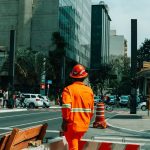 Trabalhador da construção em meio ao movimento urbano de São Paulo.
