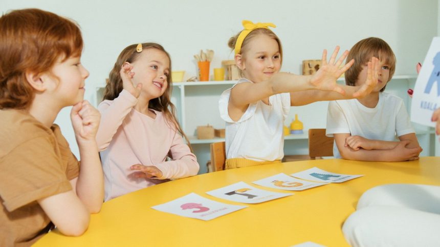 Crianças do ensino fundamental participam de uma atividade de alfabetização com cartões de letras em uma sala de aula.