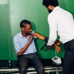 Profissional de saúde mede a pressão arterial de uma paciente em uma clínica.
